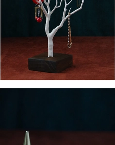 Detail of white tree branch jewelry organizer with a solid dark wood base