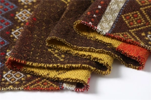 Close-up of geometric diamond weave texture and colorful fringe detail on winter shawl