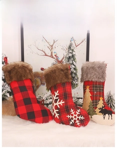 Close-up of red and black plaid Christmas stockings with snowflake and reindeer embroidery