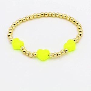 Close-up of golden beaded bracelet featuring three vibrant neon yellow enamel hearts