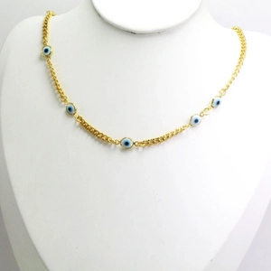 Detail of gold curb chain necklace with multiple blue evil eye pendants on a neck model