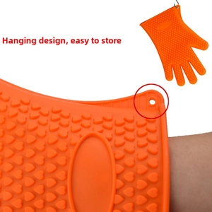 Orange silicone oven mitt with heart-shaped grip pattern and hanging hole detail
