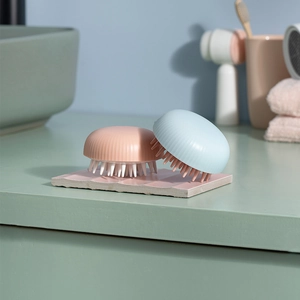 Pink and blue silicone scalp massage brushes on a display rack for wet or dry hair wash