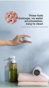 Detail of three-hole drainage system on a silicone scalp massage brush for easy cleaning