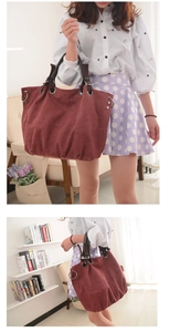 Detail of red-brown canvas tote bag with large metal rings and sturdy handles
