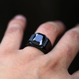 Close-up of a men's vintage stainless steel ring with a large black rectangular gemstone