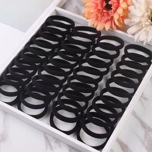 Set of 40 black seamless elastic hair ties neatly arranged in a minimalist white tray