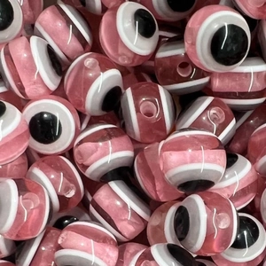 Macro detail of pink resin evil eye beads with striped patterns for DIY jewelry making