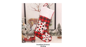 Détail d'une chaussette de Noël à carreaux rouges et noirs avec flocon de neige et fourrure