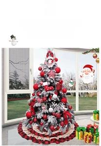 Close-up of snowy Christmas tree with red ornaments and a plaid festive tree skirt