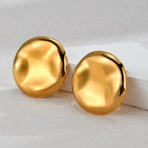 Gold irregular water ripple round stud earrings with a polished mirror finish on a white stone
