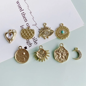 Set of gold alloy pendants with evil eye, moon, and heart designs featuring inset crystals