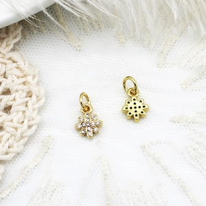 Macro shot of 18K gold micro-pave sunflower charms with white cubic zirconia stones