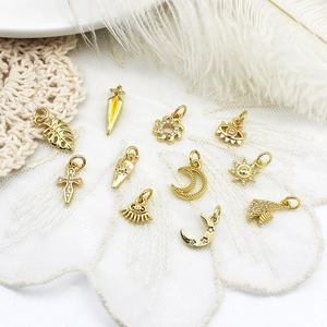 DIY gold jewelry pendants with moon sun and evil eye charms on lace fabric and feathers