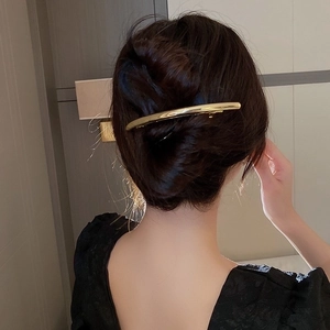 Minimalist curved gold metal hair clip for elegant bun styling in high-shine finish