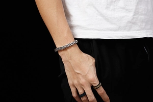Détail d'un bracelet byzantin argenté et de bagues noires sur le mannequin