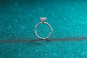 Gros plan d'une bague en moissanite avec anneau torsadé en argent et sertissage à 6 griffes