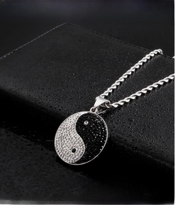 Macro shot of Yin Yang pendant in 316L stainless steel with black and white crystals