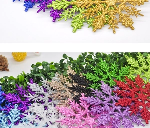 Macro detail of glittery Christmas snowflake pendants in vibrant colors on pine background