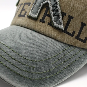 Detailed close-up of embroidery stitching and fabric texture on a washed baseball cap
