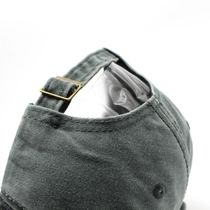Close-up of baseball cap back with adjustable metal buckle and washed cotton texture