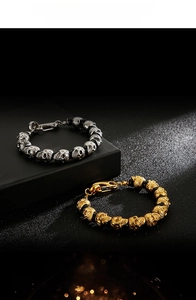 Detail of skull beaded bracelets with tiger eye stones and matte black beads in gold and silver