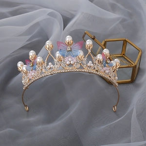 Exquisite gold princess crown with pearls, crystals and pink flowers on grey background