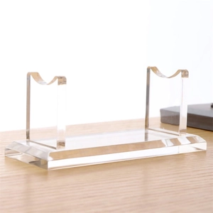 Clear acrylic pen and sword display stand with dual U-shaped brackets on a wood desk
