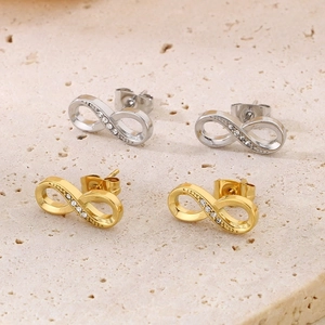 Macro shot of gold and silver infinity stud earrings with sparkling pavé crystals