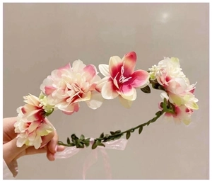Close-up of artificial fabric flower headband with pink petals and green leaves