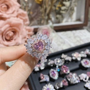 Close-up of pink heart-shaped crystal ring with teardrop stones on hand