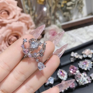Macro shot of a heart-shaped pink zircon ring with teardrop charm on a silver-plated band