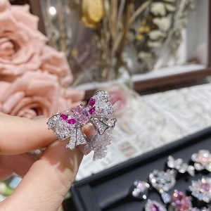 Macro shot of pink bow ring with Asscher cut zircon and silver metal finish details