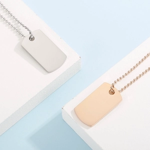 Detail showing polished silver and rose gold rectangle dog tags on bead chains