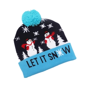 Detail of blue knitted Christmas beanie featuring snowman patterns and Let It Snow text