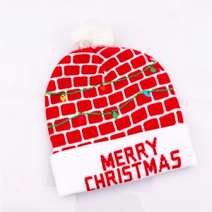 Detail of red Christmas knit hat featuring brick pattern and LED lights for parties