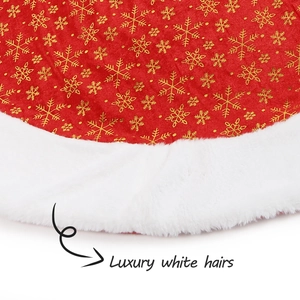 Detail of red Christmas tree skirt with golden snowflake patterns and white faux fur trim