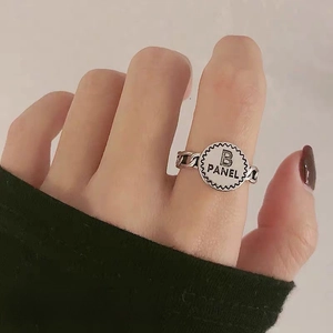 Detail of adjustable silver alloy ring featuring B PANEL engraving and chain texture