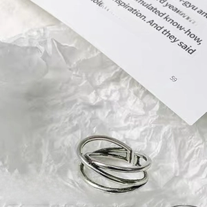 Macro shot of silver adjustable ring with multi-layer irregular twisted lines texture