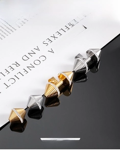 Nahaufnahme von Hantelanhängern in Gold und Silber mit weißen Zirkonia-Steinen