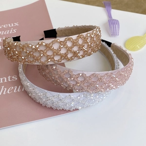 Detail of hand-woven crystal beaded headbands in champagne gold, pink, and white tones