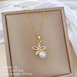 Close-up of golden butterfly pearl necklace with crystal pendant in jewelry box
