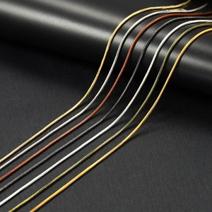 Macro detail of parallel metal snake chains in gold, silver, rose gold, and gun black colors