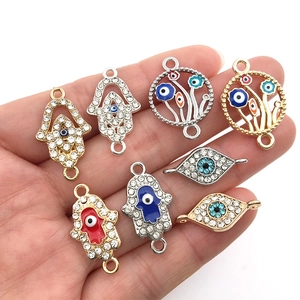 Close-up of Hamsa and Evil Eye enamel connectors with rhinestones for DIY jewelry