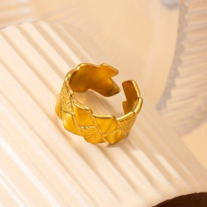 Close-up of golden hollow star ring with diamond accents and textured finish