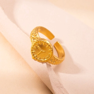Detailed close-up of a golden hollow star clock face ring with adjustable band and texture