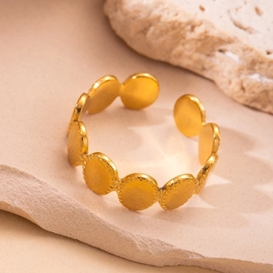 Close-up of a gold hollow star ring with diamond setting on a natural stone base