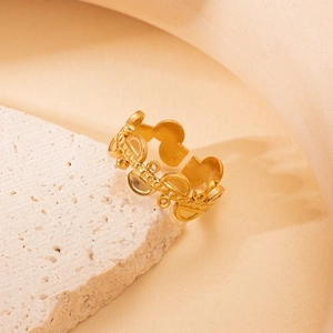 Detail showing the intricate gold lace texture and geometric bead patterns on the open ring