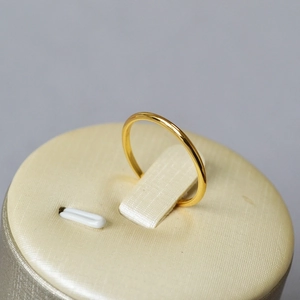 Minimalist gold plated wave ring displayed on a premium cylindrical jewelry stand