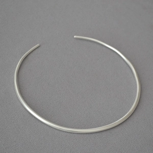 Detailed view of silver minimalist irregular open choker necklace on grey background